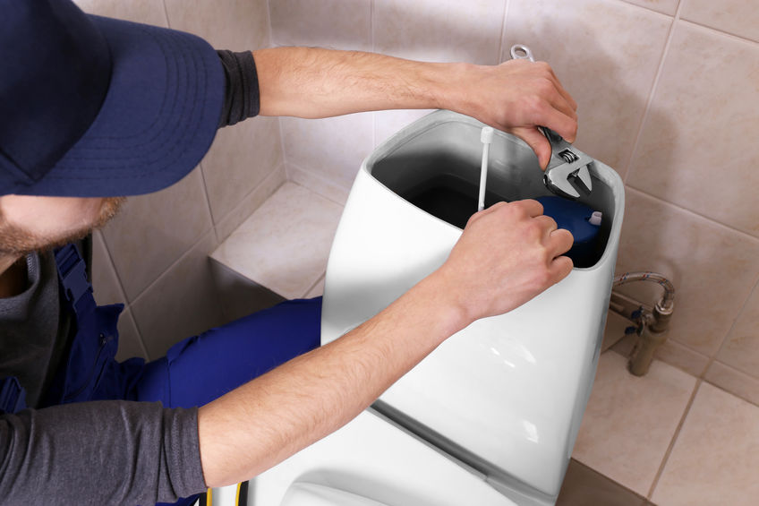 Plumber repairing toilet cistern